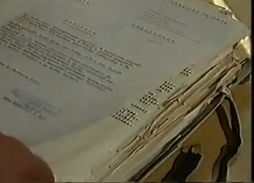 A thick stack of typed resolutions held open on a desk, the top sheet headed by the name of a national committee and stamped and signed at the foot