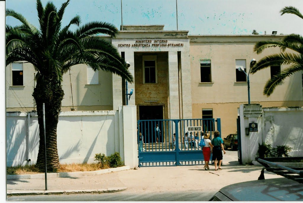 The gate and entrance road of the refugee camp at Latina, south of Rome