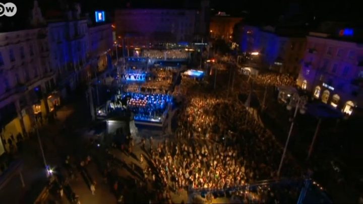 An aerial view of Zagreb's main square at night on 1 July 2013, the crowd filling the square around a lit stage for the accession celebration, the DW logo in the corner