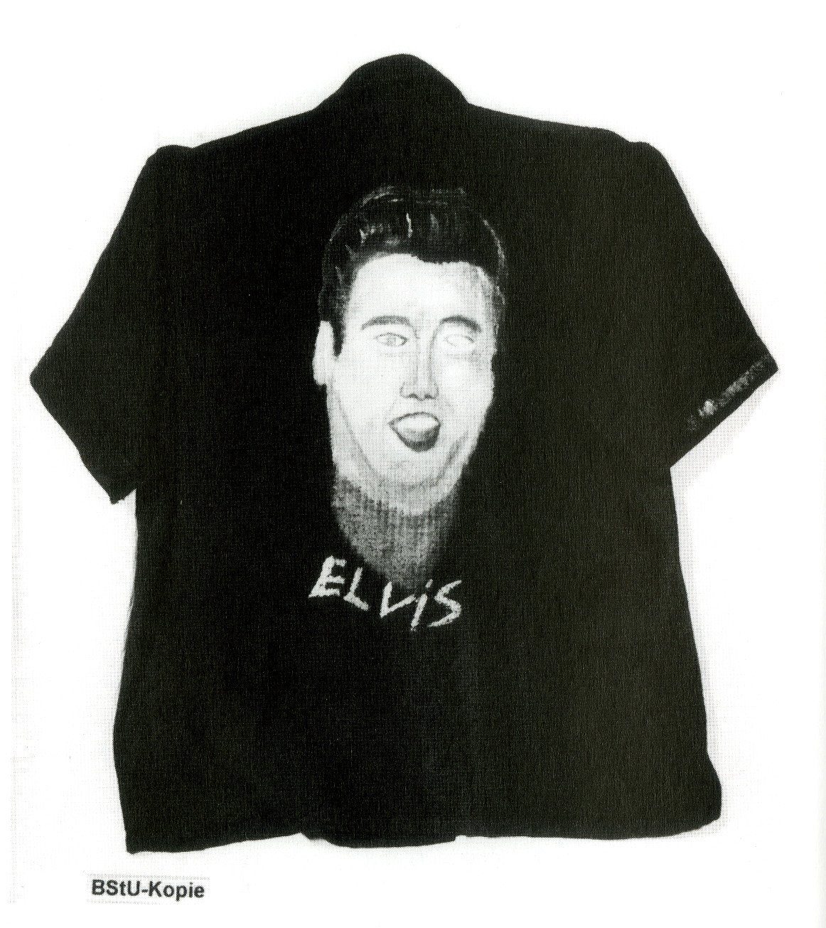 A dark short-sleeved shirt hand-painted with a face and the word ELVIS, on a white ground, with a BStU-Kopie tag