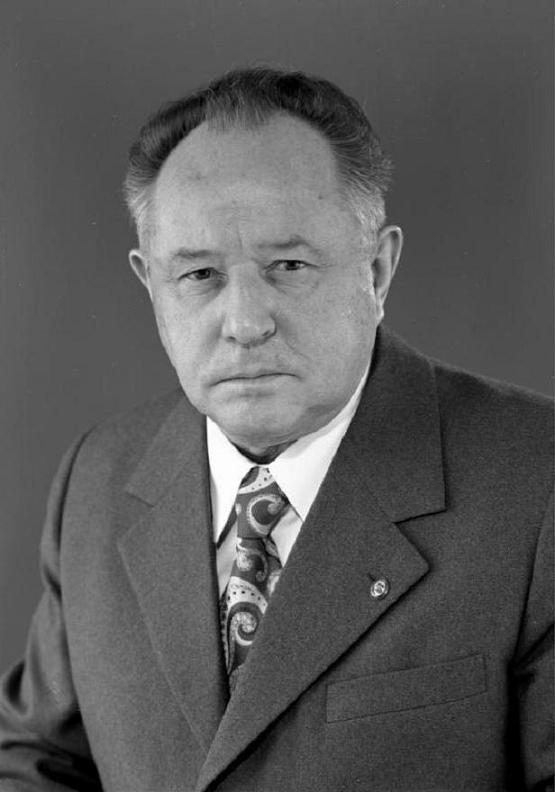 A black and white portrait of Erich Mielke in a suit and patterned tie