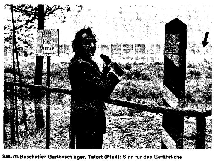 Michael Gartenschläger holding binoculars between a sign reading Halt! Hier Grenze and a striped border post, an arrow pointing past the post; captioned SM-70-Beschaffer Gartenschläger, Tatort (Pfeil)