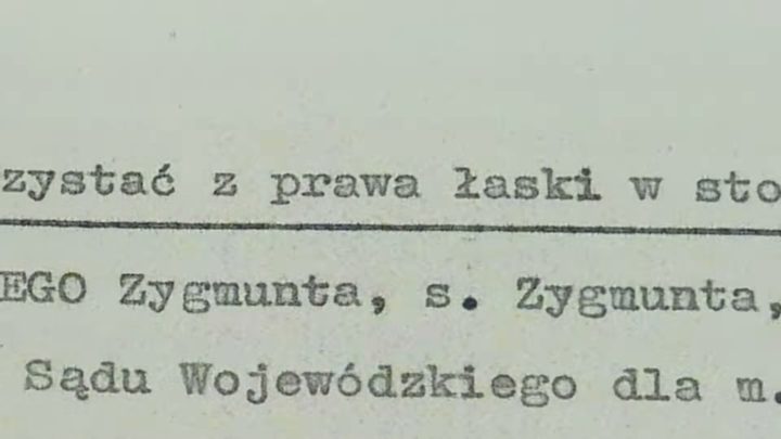 A close-up of typewritten lines on yellowed paper: z prawa łaski, Zygmunta, s. Zygmunta, Sądu Wojewódzkiego dla m.