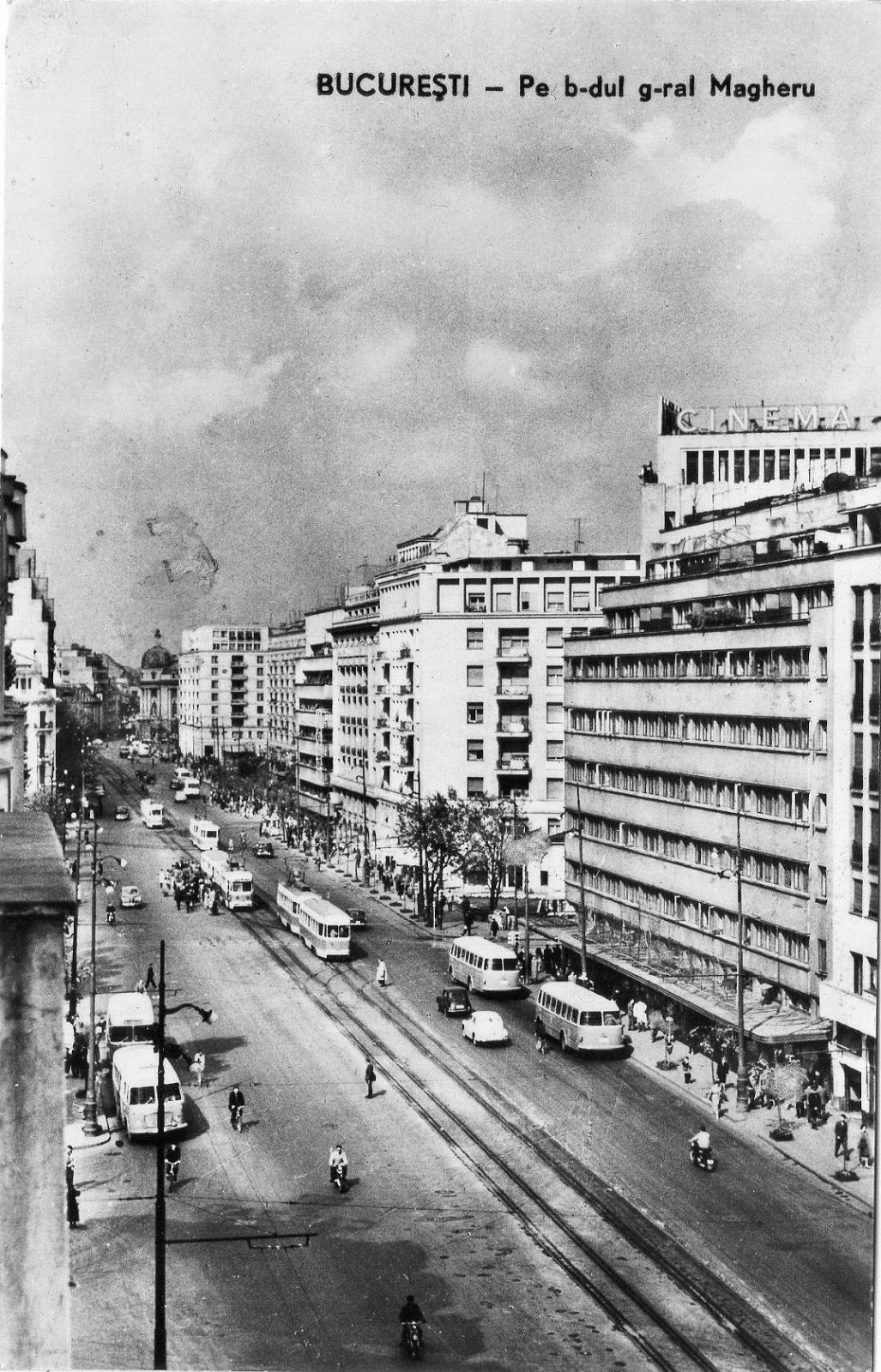 A period photograph of Bulevardul Gheorghe Magheru in Bucharest in the early 1960s, with trams, buses and pedestrians on a wide boulevard. The printed Romanian caption reads Bucuresti, pe b-dul g-ral Magheru