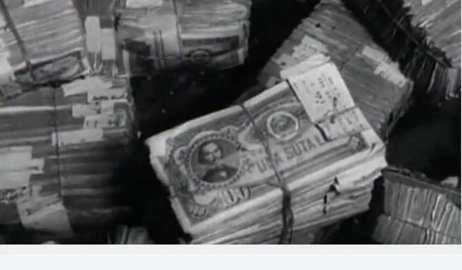 Banded bundles of banknotes seen from above, the top note reading UNA SUTĂ LEI, one hundred lei, with paper tags tucked under the bands