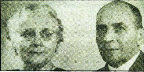 Two black and white head portraits side by side, an older woman in round glasses with her hair pinned up, and an older man in a jacket, collar and tie