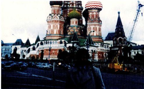 A colour snapshot taken in Red Square, Moscow, with the domes of Saint Basil's Cathedral behind and a single figure standing in the foreground