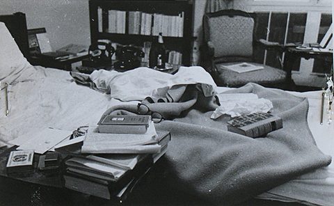 The unmade bed in Jan Masaryk's bedroom on 10 March 1948, papers and telegrams spread over the covers with two books and a pair of spectacles among them, and a bedside table carrying a telephone, a bottle and a carafe