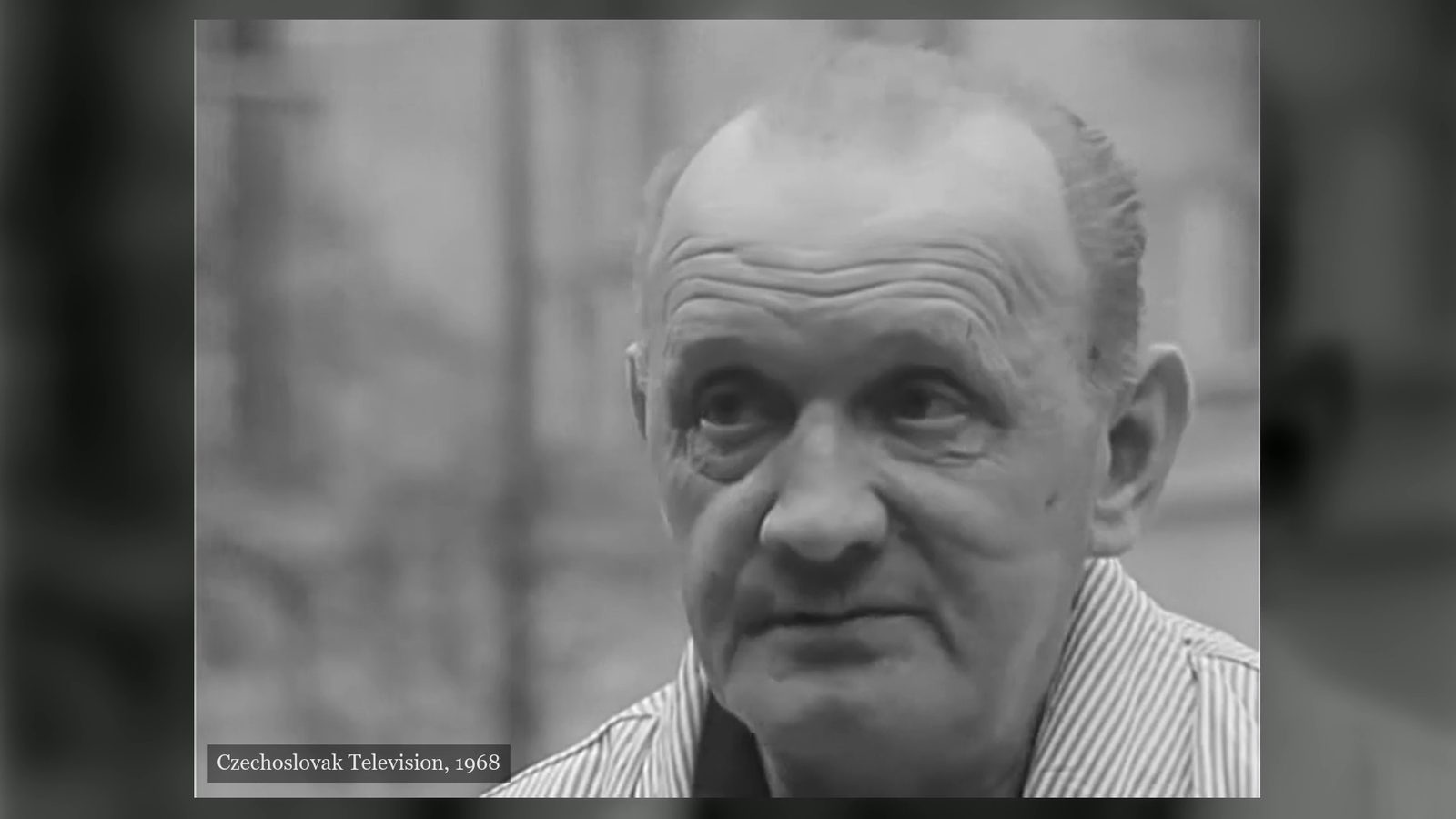 Josef Pánek filmed close up out of doors in a striped open necked shirt, the background thrown out of focus behind him, Czechoslovak Television, 1968