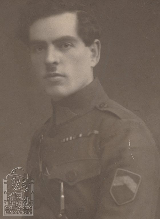 A studio portrait of Josef Pěkný in Czechoslovak Legion uniform with a shoulder patch, the emblem of the Czechoslovak Legionary Community embossed in the lower corner