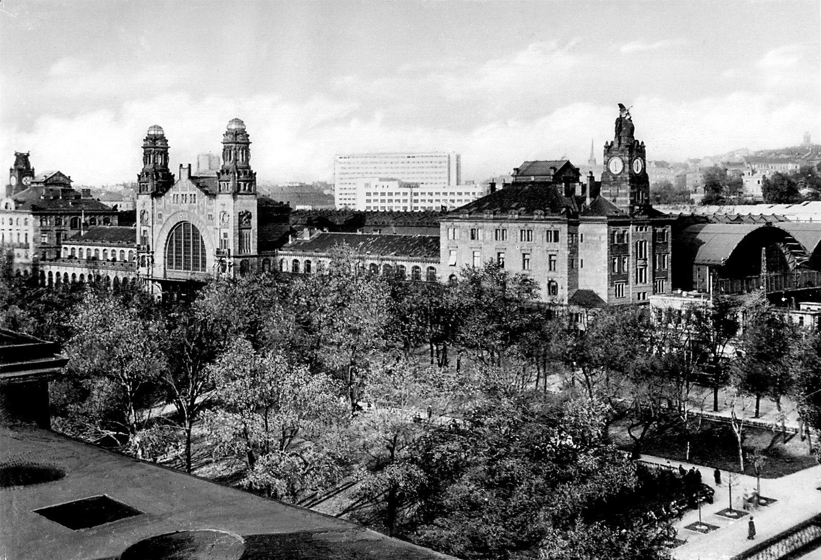 A period view across the park to the frontage and towers of Wilson station in Prague