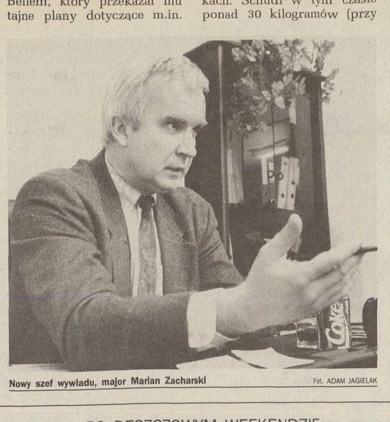 A newspaper photograph of Marian Zacharski at a desk, grey haired, in a jacket and tie, gesturing with one hand, a can of Coke on the desk, captioned Nowy szef wywiadu, major Marian Zacharski